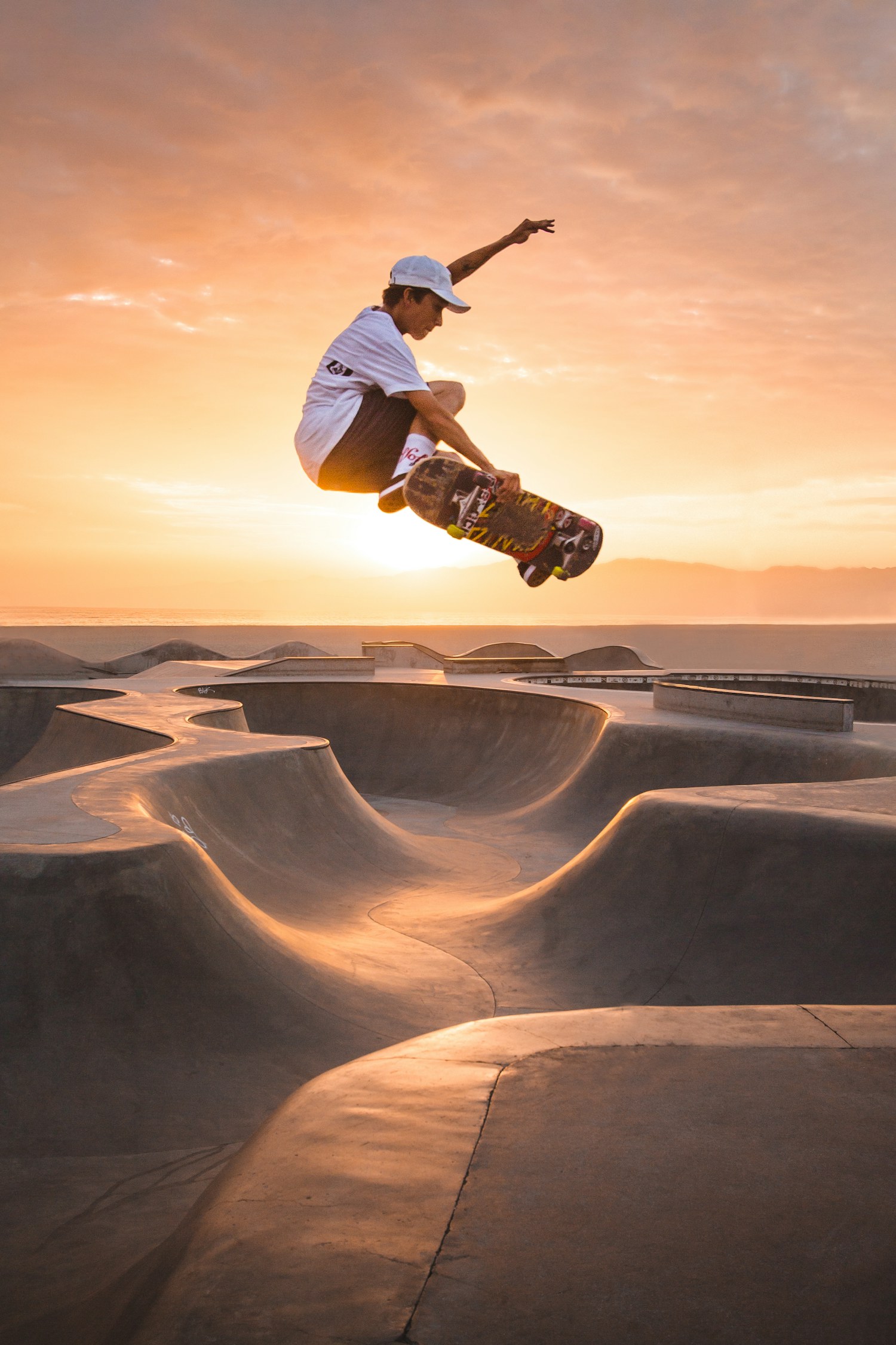 Skater in volo su una rampa contro il cielo, di sera.